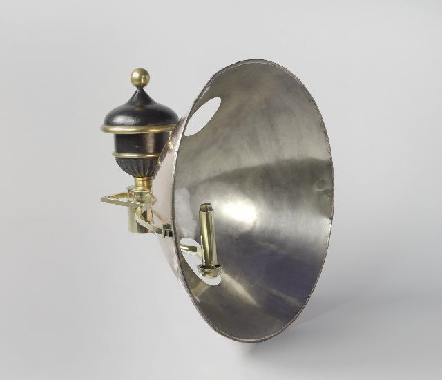 Argandse lamp met lichtkaatser voor een vuurtoren, bestaande uit een metalen reflector en een oliebrander met decoratief deksel en messing accenten